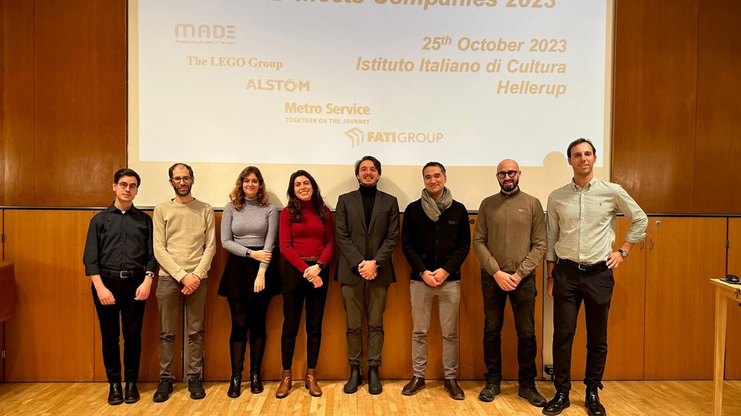 Eight ARSID contributors standing in front of a screen at the Italian Institute of Culture
